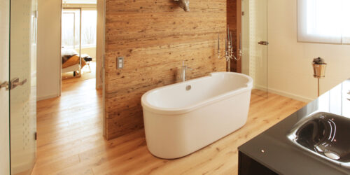Luftfeuchtigkeit in Wohnräumen – Holzvertäfeltes Badezimmer mit freistehender Badewanne.