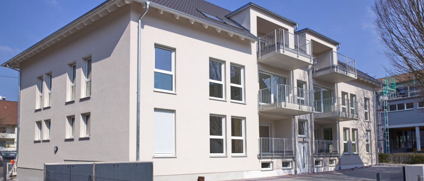Mehrfamilienhaus als Kapitalanlage – Ein Mehrfamilienhaus von Rötzer mit weißer Fassade.
